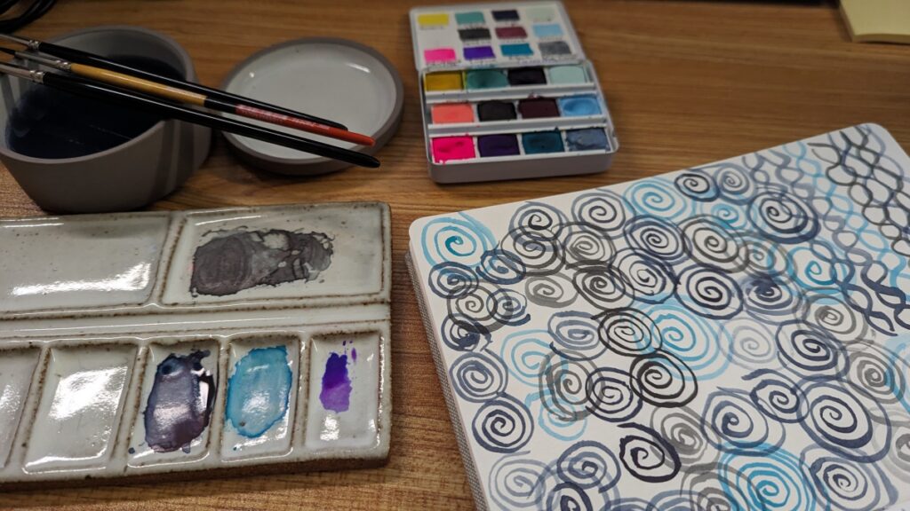 Watercolor paints and abstract watercolor painting in a journal