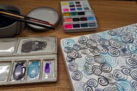 Watercolor paints and abstract watercolor painting in a journal