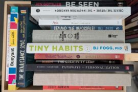 Creativity and innovation books stacked in the a box with the titles facing out.