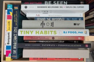 Creativity and innovation books stacked in the a box with the titles facing out.