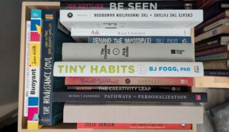 Creativity and innovation books stacked in the a box with the titles facing out.