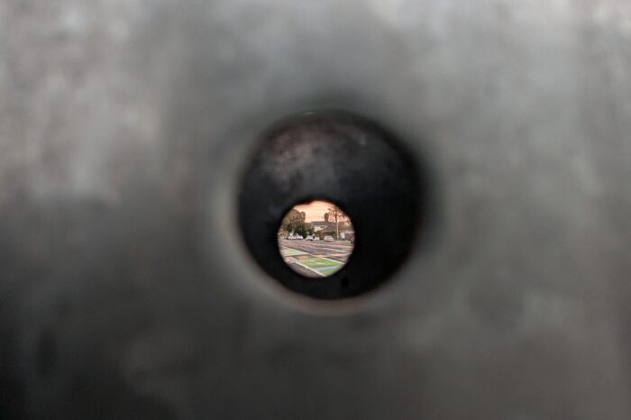 Looking at a street through a street sign pole