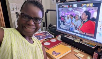 Dr Abigail working at her desk with Zoom window open to Speak & Write 2025